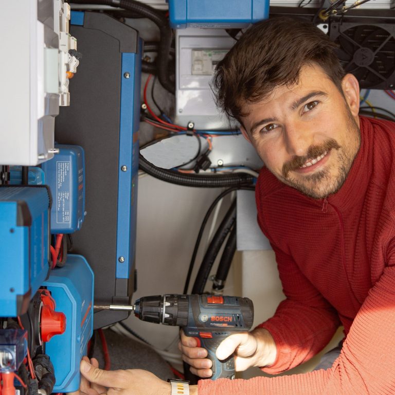 Alberto montando un sistema eléctrico camper en una furgoneta, instalación personalizada de CastleVans para viajes largos y uso intensivo